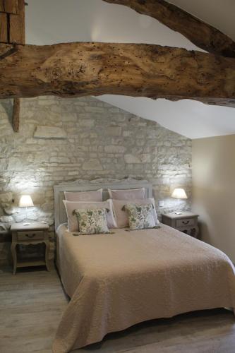 een slaapkamer met een bed met 2 nachtkastjes en 2 tafels bij La Douce Charentaise in Mérignac