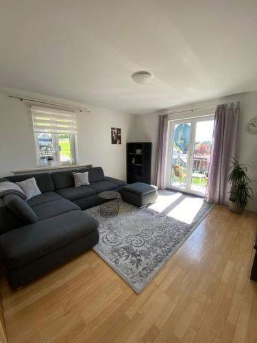 a living room with a black couch and a rug at Ferienwohnung Lara in Tiefgraben