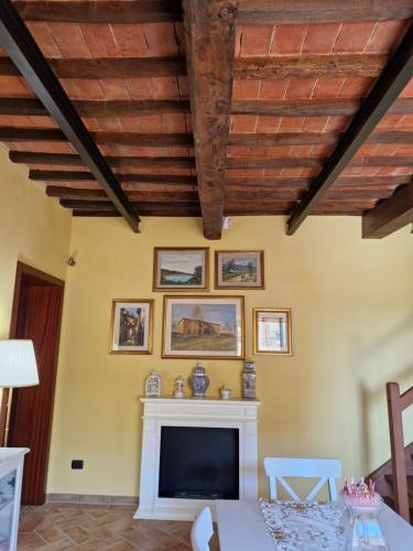 a living room with a fireplace and a wooden ceiling at Country Apartment with View of the Tuscany Hills in Peccioli