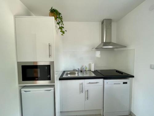 a white kitchen with a sink and a microwave at Thuit de l'Oison - Superbe appartement F2 duplex in Le Thuit-Simer