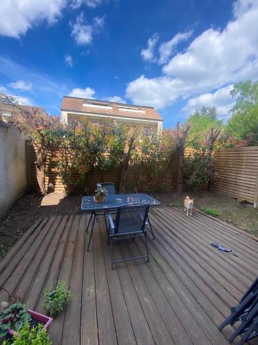 - une table de pique-nique sur une terrasse en bois avec un chien dans l'établissement Charmant appartement 1 pièce principale avec terrasse privée proche de toutes commodités, à Fontenay-sous-Bois