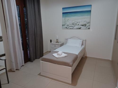 un pequeño dormitorio con una cama y una pintura en la pared en Heraklion Comfy House with Mountain View, en Heraclión