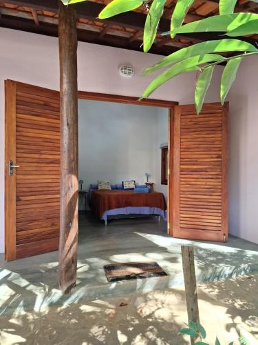 a bedroom with a bed and a wooden door at Casa Papa-Vento in Lençóis