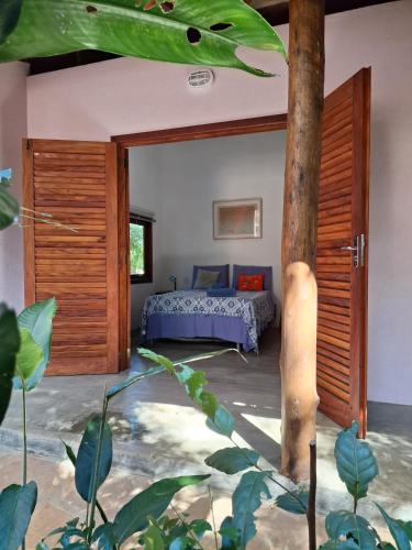 een slaapkamer met een bed en een boom bij Casa Papa-Vento in Lençóis