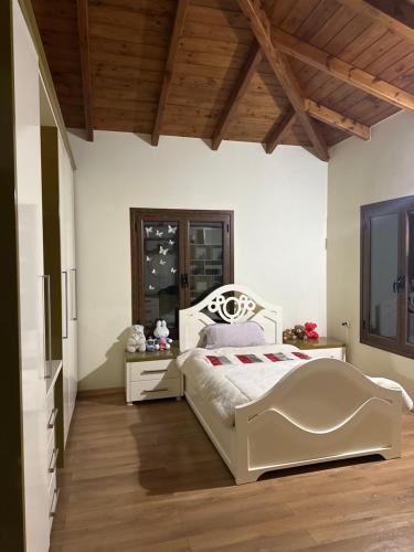 1 dormitorio con cama blanca y techo de madera en Alibeja villa en Pashalli