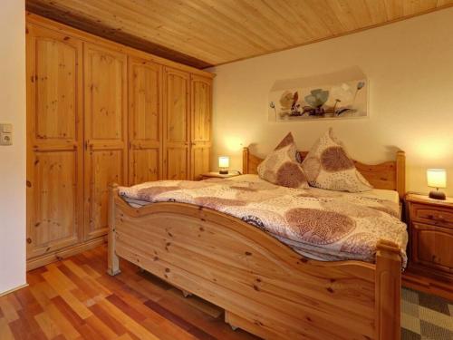 a bedroom with a large wooden bed with two lamps at Waldhaus Sonnenberg Apartment 3 in Drachselsried
