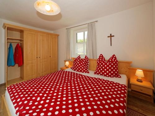 a bedroom with a red and white bed with red pillows at Waldhaus Sonnenberg Apartment 2 in Drachselsried