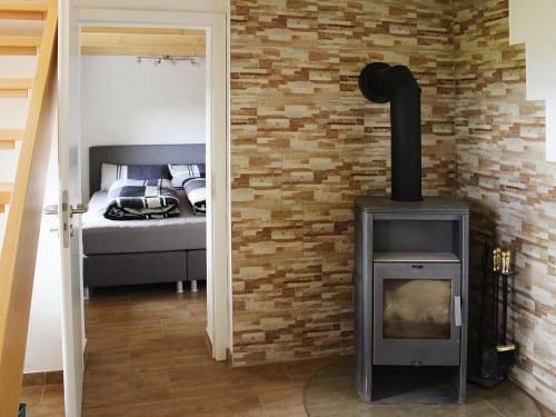 a wood stove in a room with a bedroom at Cottage, Kaltennordheim in Kaltennordheim