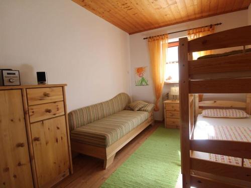 a bedroom with a couch and a bunk bed at Haus Staffelberg App 802 in Freudensee