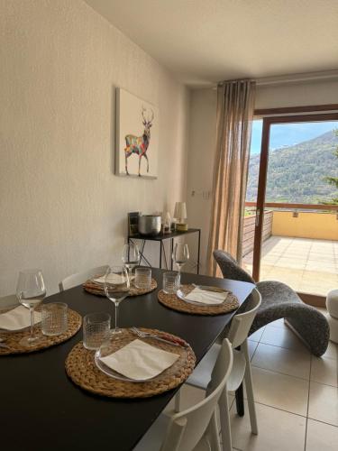 - une salle à manger avec une table et des chaises offrant une vue dans l'établissement Appartement cosy Briançon, à Briançon