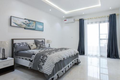 a white bedroom with a bed and a window at Residence Mandela Almadies Dakar, Senegal, Ngor Almadies in Ngor