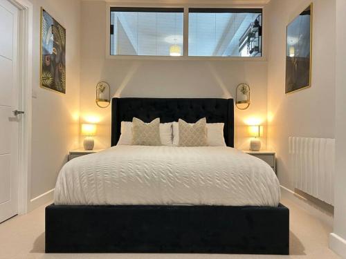 een slaapkamer met een groot bed met een zwart hoofdeinde bij Trendy City Centre Apartment with FREE Parking in Southampton