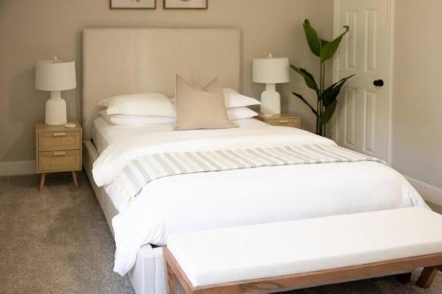 a bedroom with a large white bed with two night stands at Refreshing Ranch Style Home in McDonough