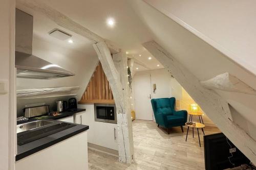 une cuisine mansardée avec un évier et une chaise bleue dans l'établissement Verneuil sur Avre - Superbe appartement Cosy, à Verneuil-sur-Avre