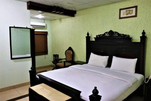 um quarto com uma cama grande e uma cabeceira preta em InTown Guesthouse em Islamabad