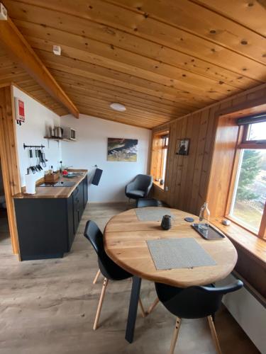 uma cozinha com mesa e cadeiras num quarto em Hengifosslodge Skáldahús em Egilsstadir