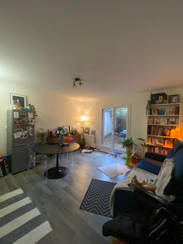 sala de estar con sofá y mesa en Charmant appartement avec terrasse privée, en Fontenay-sous-Bois