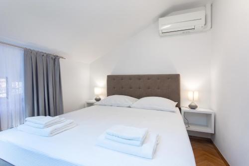 a bedroom with a white bed with towels on it at Apartmaji pri Perotu in Izola