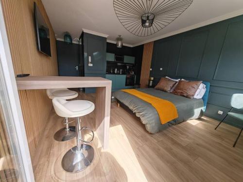 - une chambre avec un lit et une table avec un tabouret dans l'établissement Appartement cosy climatisé, à La Rochelle