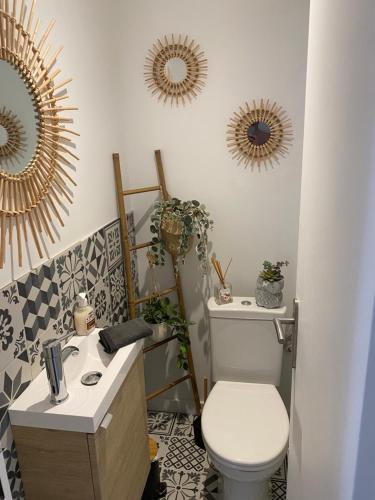 La salle de bains est pourvue de toilettes et de 3 miroirs sur le mur. dans l'établissement Bel appartement en résidence avec 3 piscines, à Mandelieu-la-Napoule