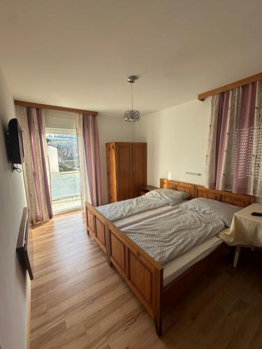 um quarto com uma cama grande e uma janela em Leo's Pension em Bad Schallerbach