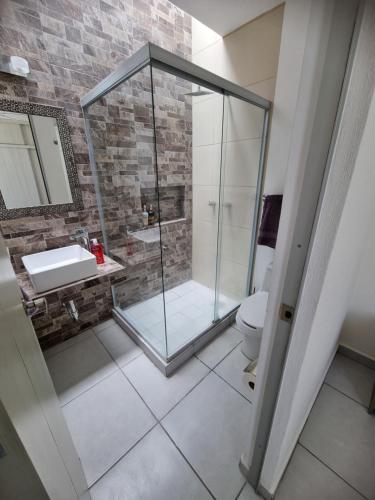 a bathroom with a glass shower and a toilet at Casa Denali in Aguascalientes