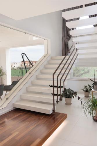 a white staircase in a house with potted plants at CORTE REALE Luxury B&B in San Salvo