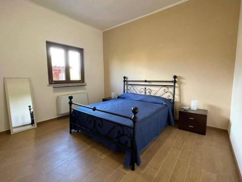 Un dormitorio con una cama azul y una ventana en Il Glicine di Luna, en Torrimpietra