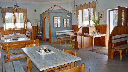 a restaurant with tables and chairs and a house on the wall at Rožmberská Chalupa in Třeboň