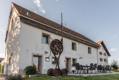 a building with a sculpture in front of it at Le Paysan Horloger in Les Bois