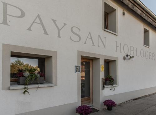 a sign on the side of a building at Le Paysan Horloger in Les Bois
