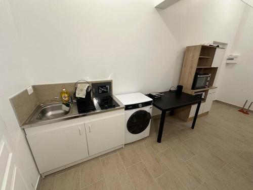 une petite cuisine avec un évier et une cuisinière dans l'établissement Studio dans une maison 2/3, à Aulnay-sous-Bois