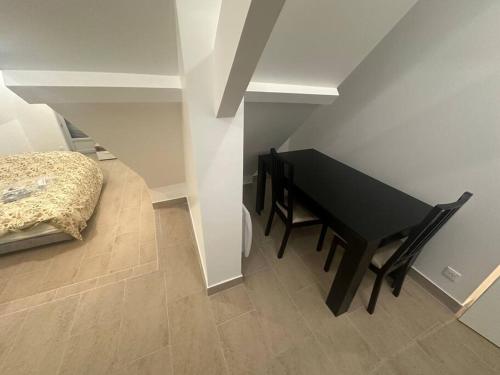 - une table et une chaise noires dans une chambre avec un lit dans l'établissement Studio dans une maison 2/3, à Aulnay-sous-Bois