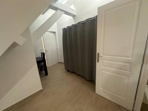 a hallway with a white door and a row of stalls at Studio dans une maison 2/3 in Aulnay-sous-Bois