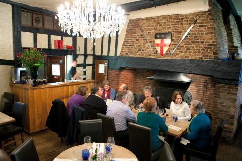 a group of people sitting at tables in a restaurant at The George Hotel & Brasserie, Cranbrook in Cranbrook