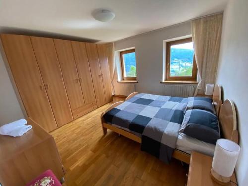 sypialnia z łóżkiem z kocem szachowym w obiekcie Appartamento da Romano - nel cuore delle Dolomiti w mieście Danta