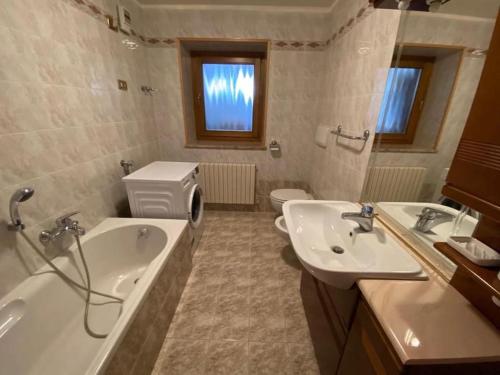 łazienka z 2 umywalkami i toaletą w obiekcie Appartamento da Romano - nel cuore delle Dolomiti w mieście Danta
