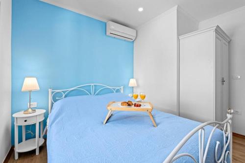 a blue bedroom with a blue bed with a tray on it at Old Tower Center Apartment in Pula