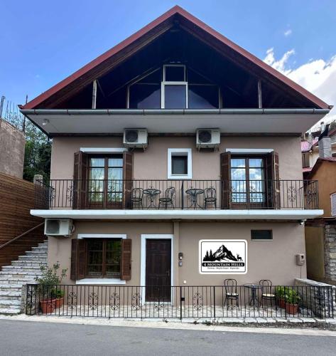 Casa con balcón con mesas y sillas en 4 MOUNTAIN HILLS, en Méga Khoríon