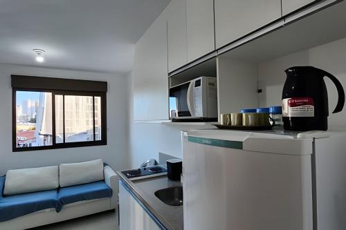 a kitchen with a couch and a table in a room at H.E 704 · Comodidade no Caminho Das Árvores in Salvador