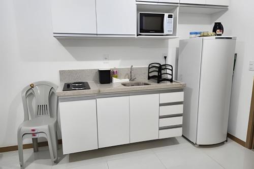 a kitchen with a white refrigerator and a microwave at H.E 704 · Comodidade no Caminho Das Árvores in Salvador