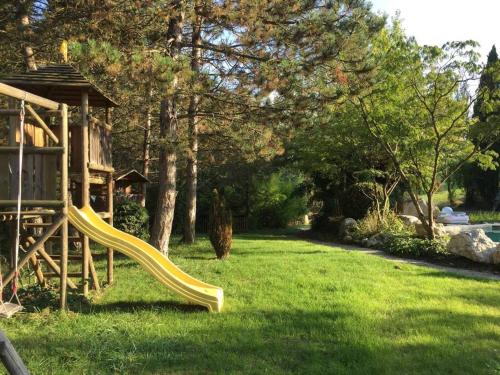 a playground with a slide in a yard at French Farmhouse between Lake & Mountain in Héry-sur-Alby