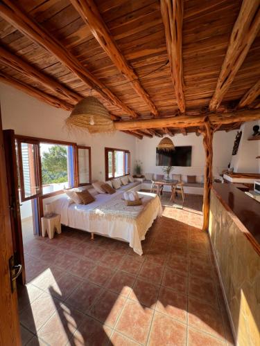 sypialnia z dużym łóżkiem w pokoju z drewnianym sufitem w obiekcie Villa Cala Xuclar w Portinatx