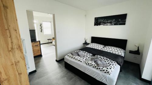 a bedroom with a black and white bed in a room at Henry Apartment Nesvady in Nesvady