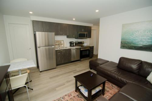 a living room with a couch and a kitchen at Niagara Escape Crib: 3km from NiagaraFalls in Niagara Falls