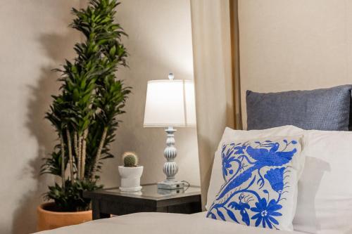 a bed with a blue and white pillow and a lamp at Casa Tranquilo, 4BR Home by Rosewood with Hot Tub in San Miguel de Allende