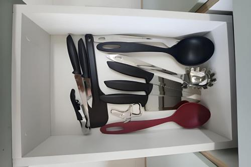 a white drawer filled with lots of kitchen utensils at Conforto no Caminho das árvores in Salvador