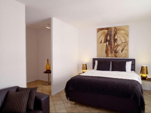 1 dormitorio con 1 cama y una pintura en la pared en VISIONAPARTMENTS Chemin des Epinettes - contactless check-in, en Lausana