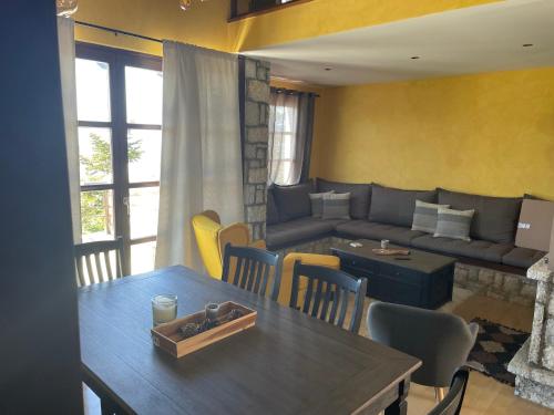 a living room with a table and a couch at Delphi Gorge-view Chalet, Arachova in Arachova