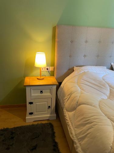 a bed with a night stand with a lamp on it at Delphi Gorge-view Chalet, Arachova in Arachova